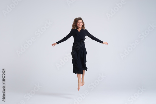 Foto Cheerful young woman jumping up in the air
