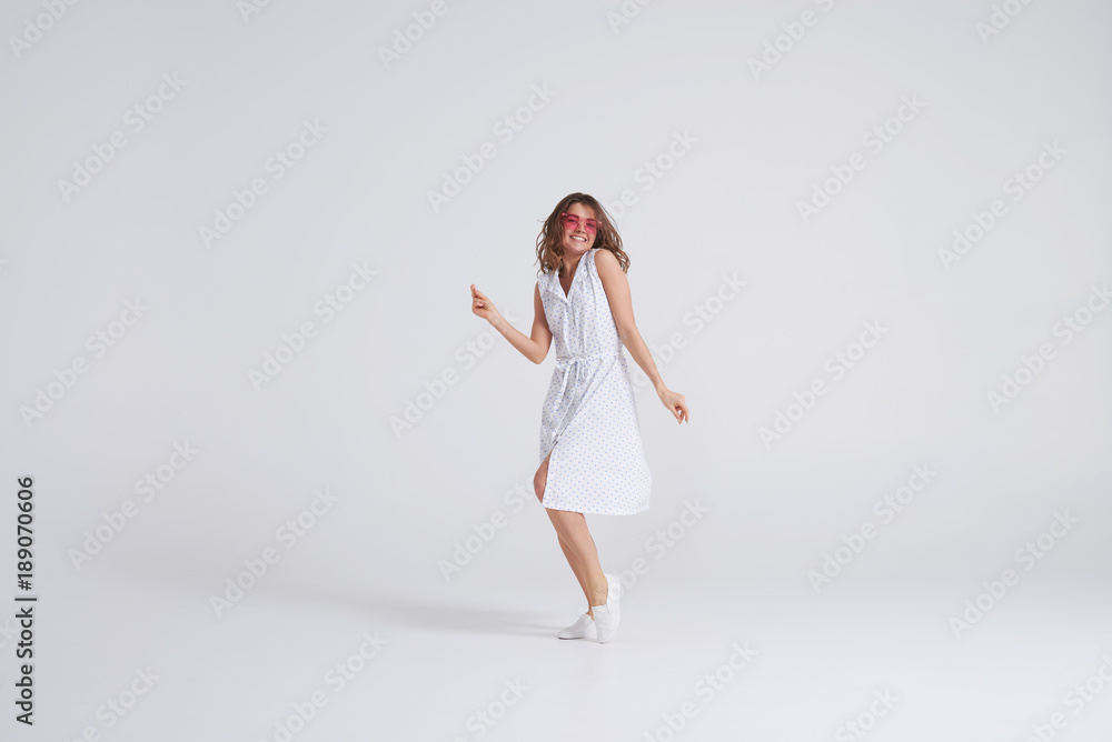 Attractive girl in dress dancing in studio on white background Attractive girl in dress dancing in studio on white background