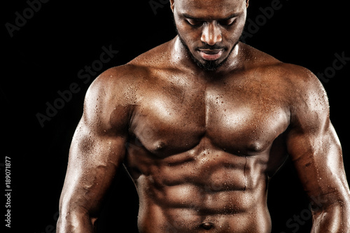 Sports wallpaper on dark background. Power athletic guy bodybuilder.