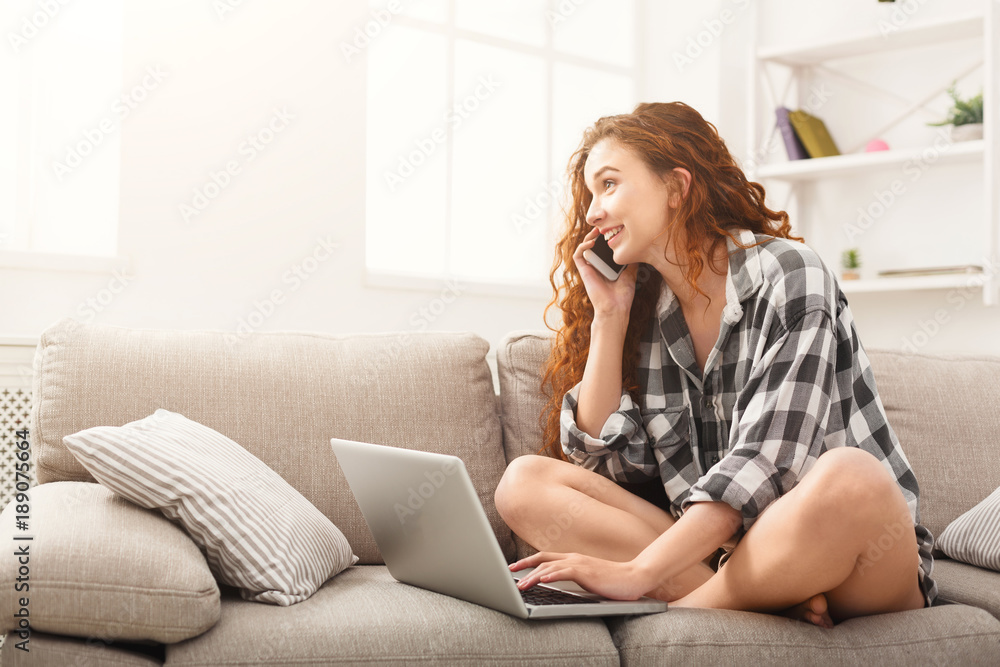 Girl with laptop and mobile sitting on beige couch. Girl with laptop and mobile sitting on beige couch.