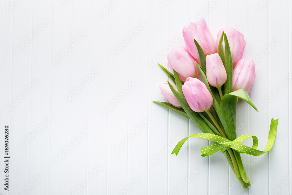 Fototapeta premium Świeży czerwony tulipan kwitnie bukiet na półce przed drewnianą ścianą.