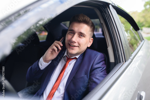 Businessman communicates by phone in the car.