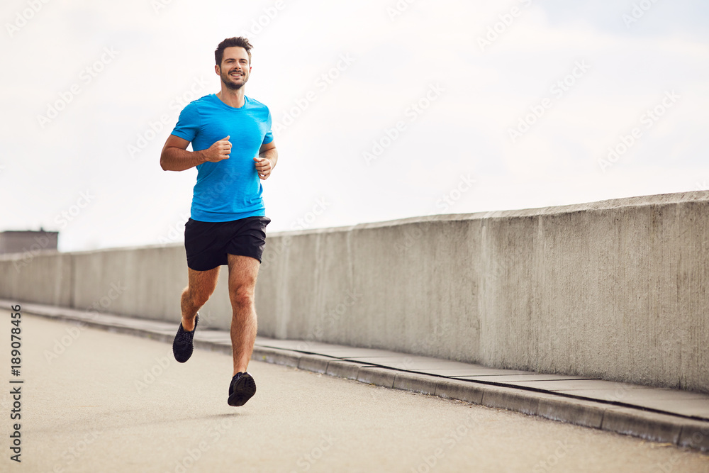 Athletic young man running Stock Photo | Adobe Stock