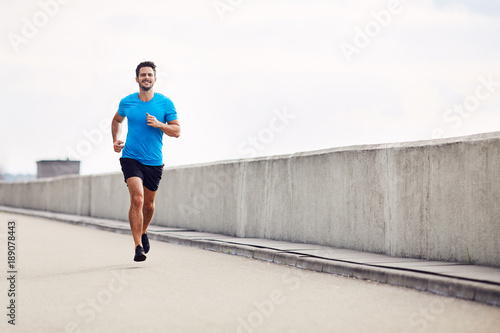 Handsome man running outdoors