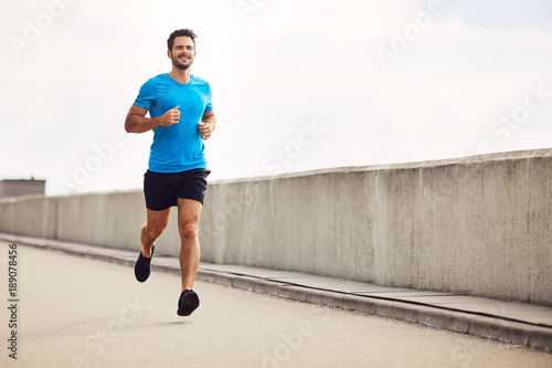 Athletic young man running photo