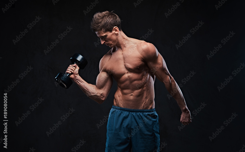 Athletic shirtless male biceps dumbbell workout.