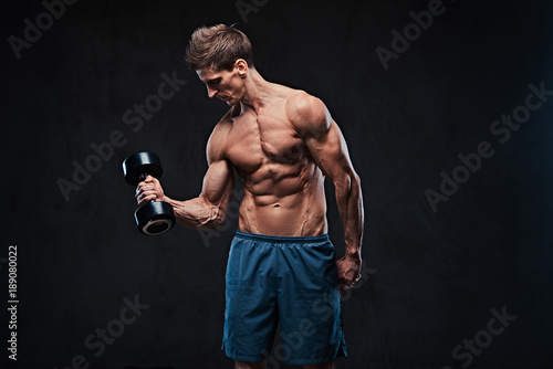 Athletic shirtless male biceps dumbbell workout. © Fxquadro