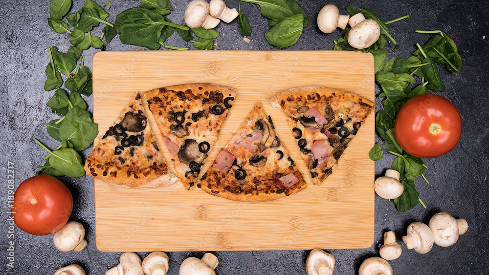 Four slices of delicious pizza on wooden board Four slices of delicious pizza on wooden board