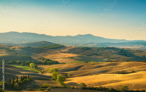 Tuscany countryside panorama, rolling hills and fields at sunrise. Italy