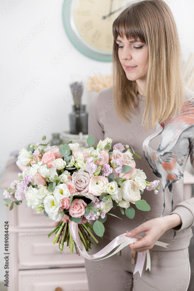beautiful luxury bouquet of mixed flowers in woman hand. the work of the florist at a flower shop. cute lovely girl