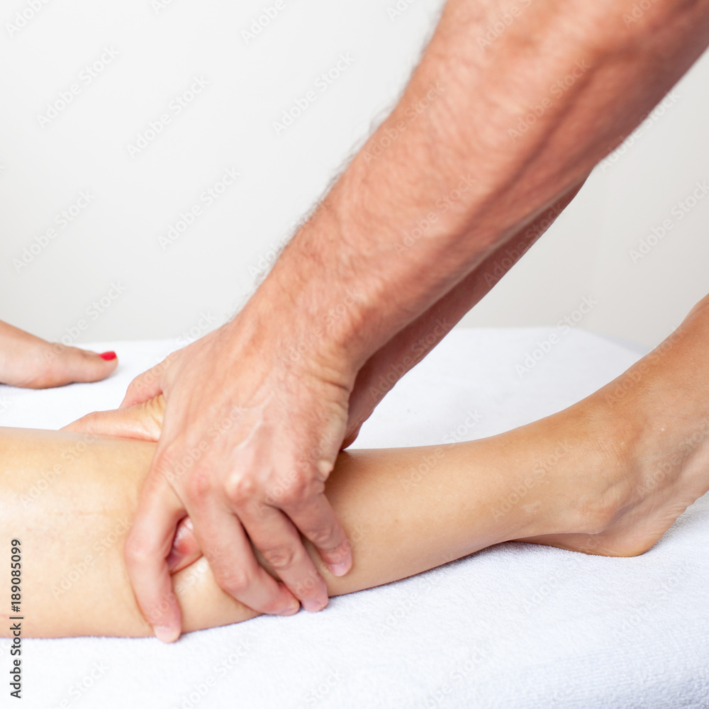 Fototapeta premium Masseur giving a lower thigh massage