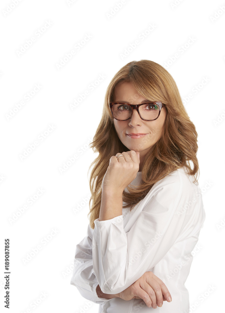Attractive middle aged woman with toothy smile posing at studio against isolated background
