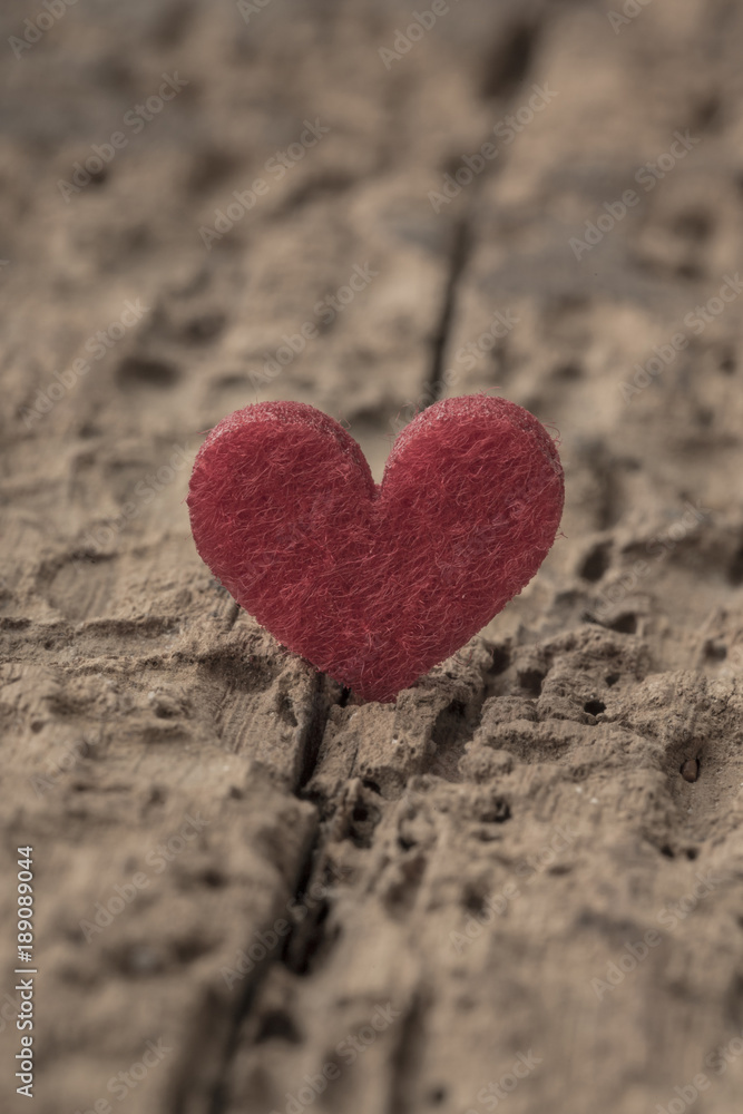 A small red heart on wooden background A small red heart on wooden background