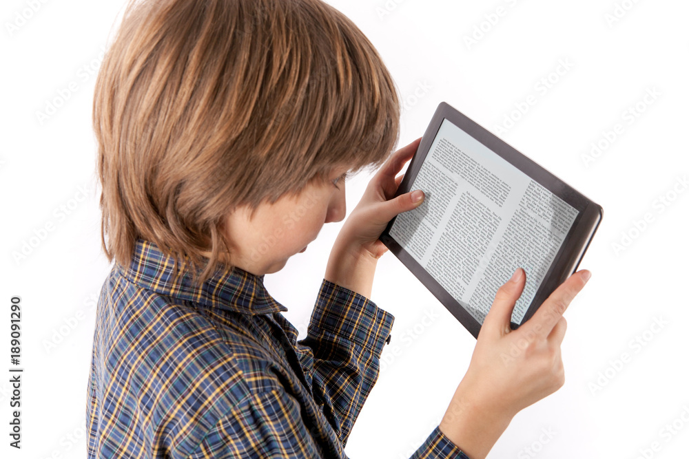 Table pc and other gadgets can cause eye problems - Young boy reading an article on a tablet device holding it too close to his eyes. Isolated on white. Table pc and other gadgets can cause eye problems - Young boy reading an article on a tablet device holding it too close to his eyes. Isolated on white.