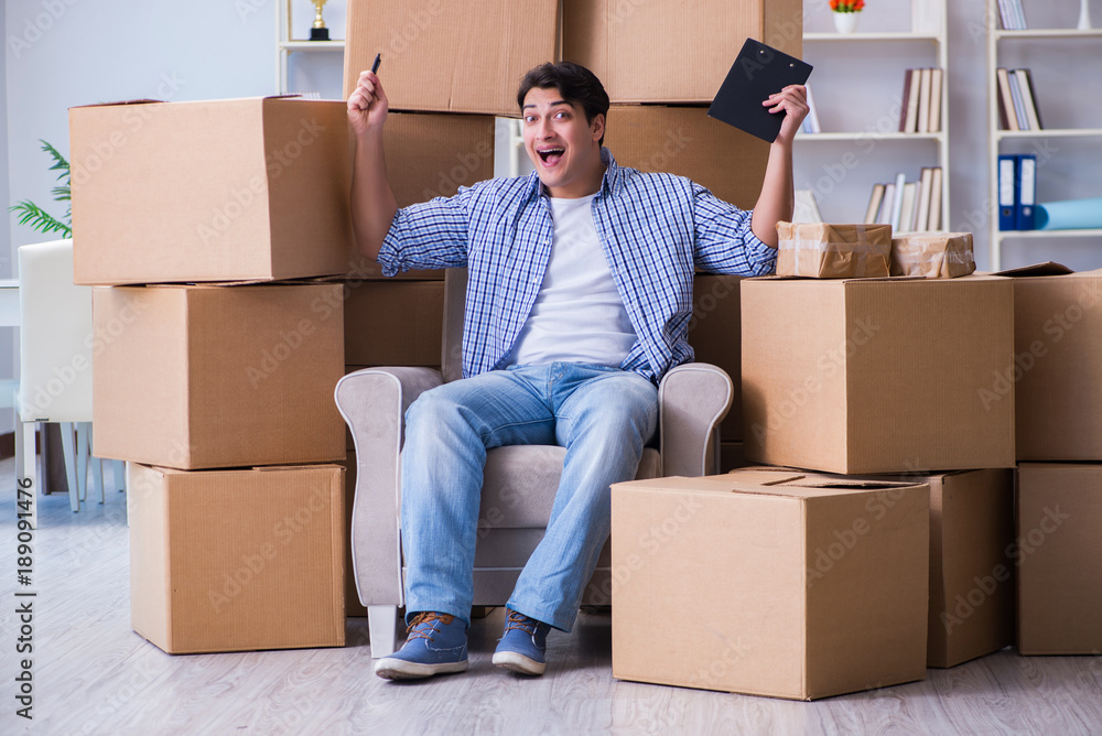 Young man moving in to new house with boxes Young man moving in to new house with boxes