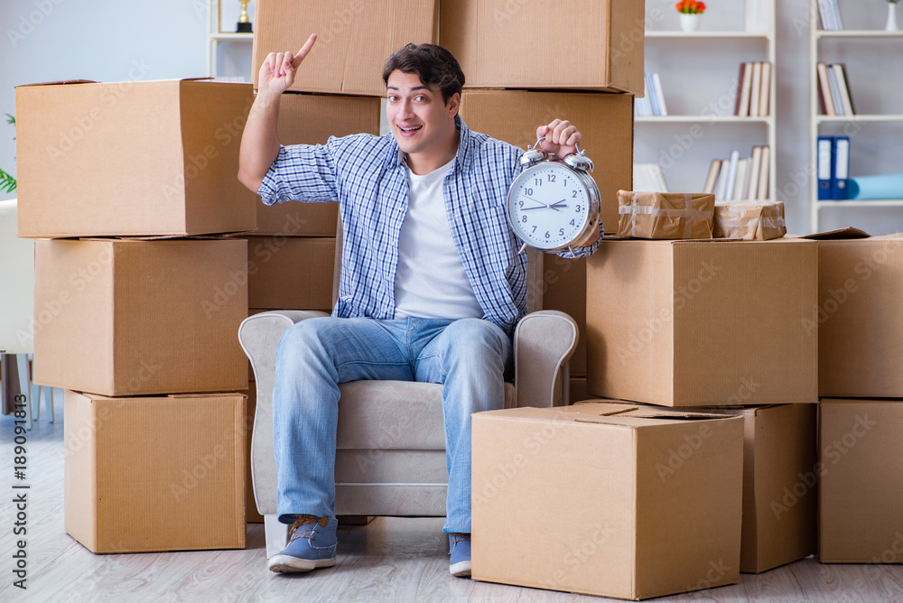 Young man moving in to new house with boxes Young man moving in to new house with boxes