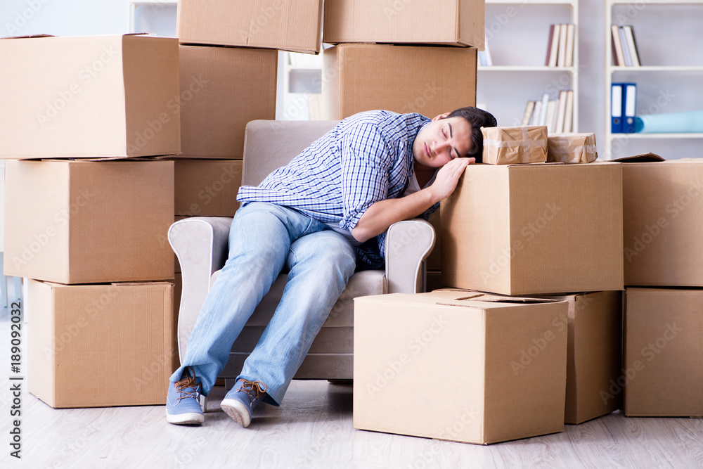 Young man moving in to new house with boxes Young man moving in to new house with boxes