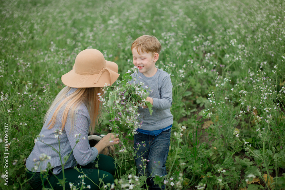 Happy mom and son play in the park in spring. Happy mom and son play in the park in spring.