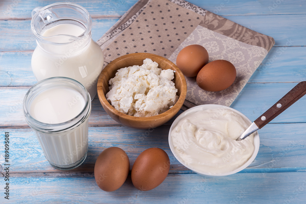 Tasty dairy products on blue wooden background Tasty dairy products on blue wooden background