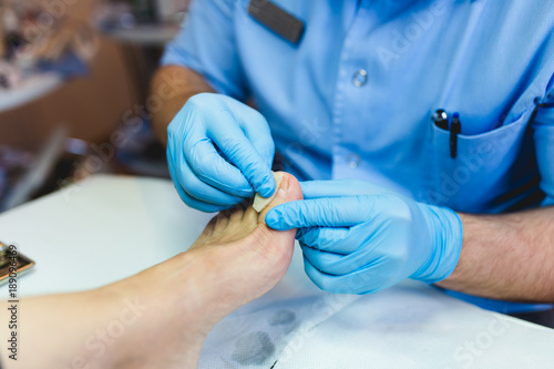 Doctor specialist giving pedicure treatment to his patient.