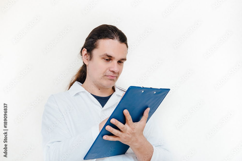 Man in white coat, doctor or scientist writes some notes into on paper pad 