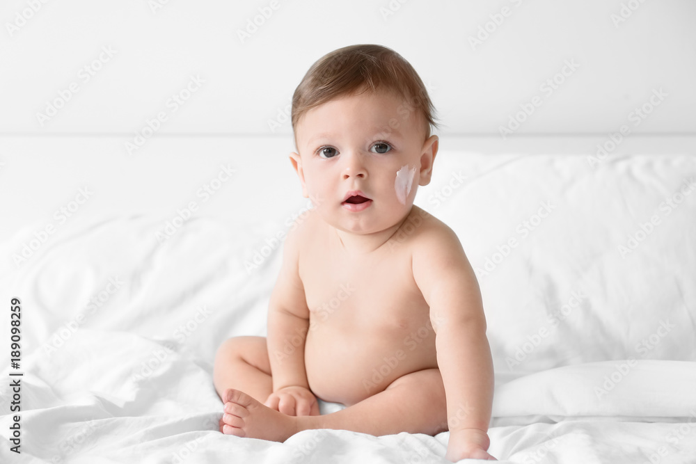 Cute baby with body cream on cheek indoors Cute baby with body cream on cheek indoors