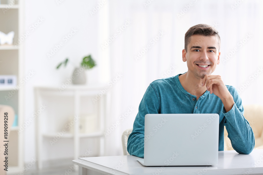 Young man using modern laptop at table Young man using modern laptop at table