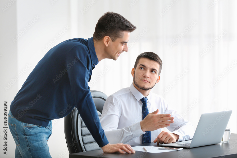 Young men with laptop at table Young men with laptop at table
