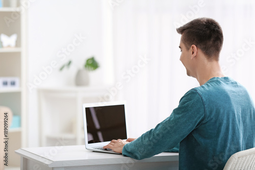 Young man using modern lapt...