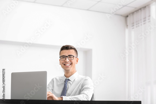 Young man in shirt using la...