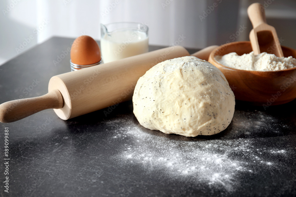Raw dough with flour and rolling pin on table Raw dough with flour and rolling pin on table