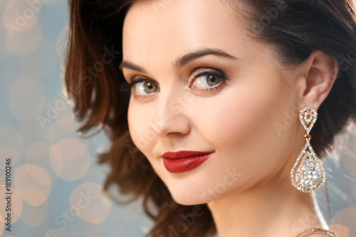 Beautiful woman with elegant jewelry against defocused lights