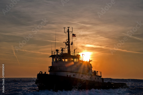 tugboat in Lake Michigan ice at sunset