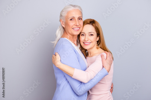 Grandparent maternity friendship touching relatives concept. Portrait of cheerful cute lovely sweet beautiful mommy and adult daughter isolated on gray background copy-space