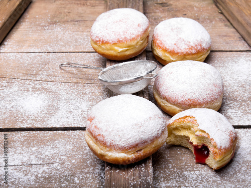 Traditional Polish donuts on wooden powder. Tasty doughnuts with jam.