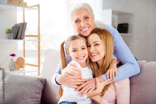 Close up portrait of excited cheerful comfort sweet friendly touching supporting cute beautiful with blonde hair ponytails schoolgirl beautiful mom charming granny hugging her family members