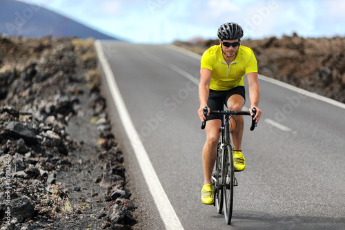 Road bike cyclist man cycling. Biking Sport fitness athlete biking on road bike. Active healthy sports lifestyle athlete cycling outside training for triathlon.
