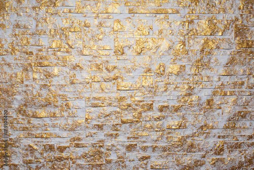 Bricks wall painted in white and gold. Background and texture