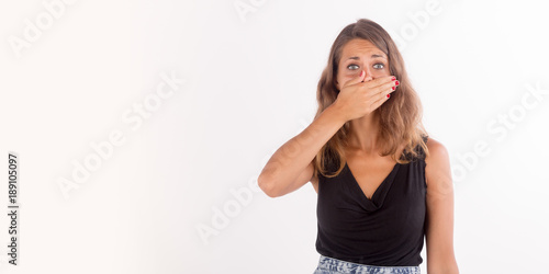 Beautiful girl with a hand on the mouth; isolated photo with copy space