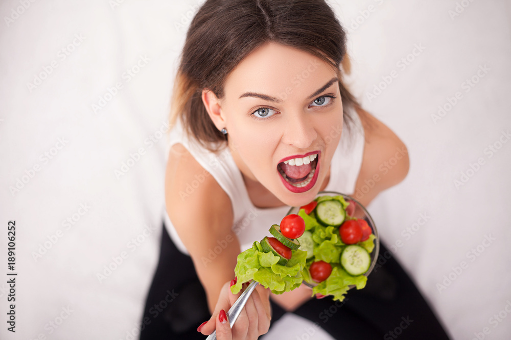 Young woman eating healthy salad after workout Young woman eating healthy salad after workout