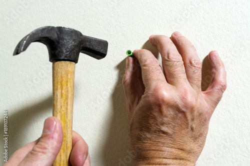 electrician  placing rawlplug with hammer photo