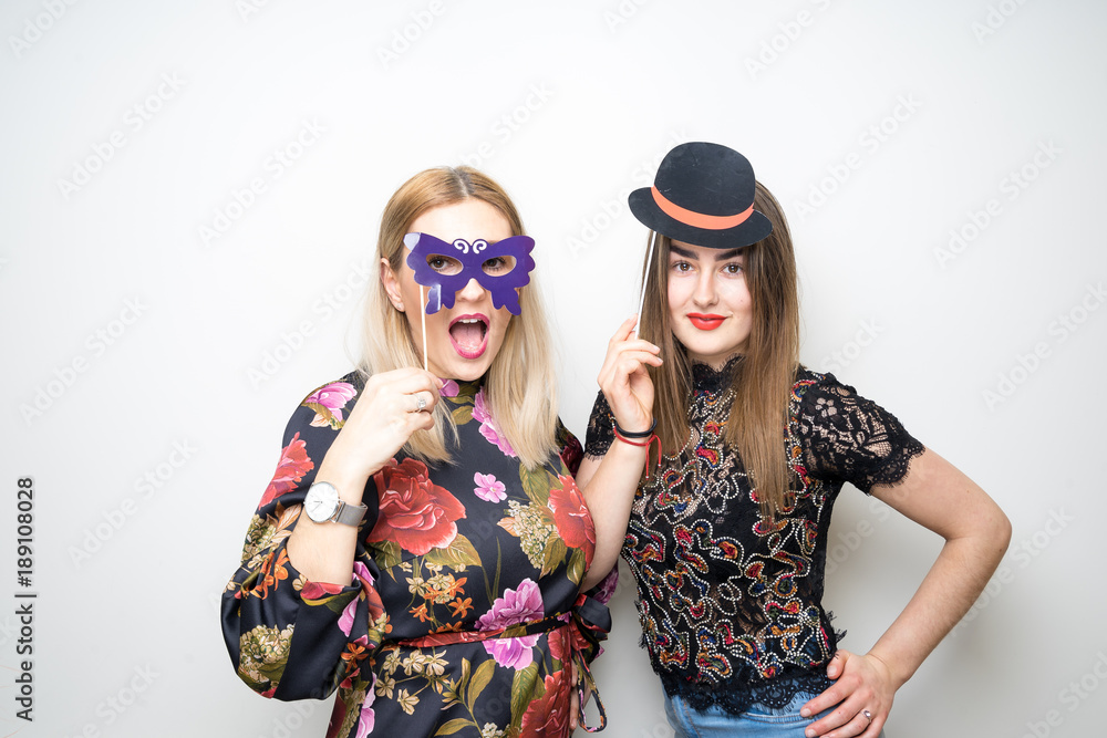 two girls posing party props photo booth white background studio drunk happy laugh
