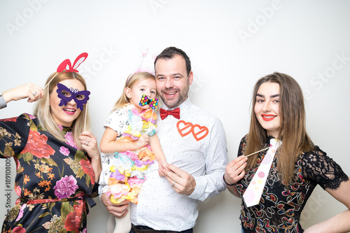 Obraz na płótnie young family posing party photo booth props baby girl plain background studio w salonie