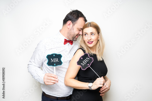 young couple posing party props white background camera wedding