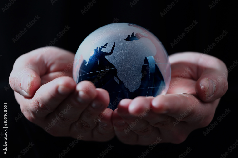 Hand holding translucent globe with blue background. Hand holding translucent globe with blue background.