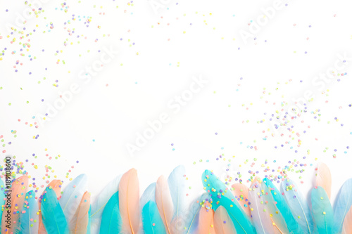 Feathers for a carnival costume. Colored confetti. White background. Pastel shades.