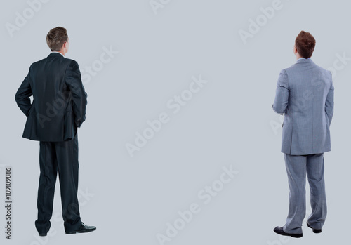 two business mans from the back - looking at something over a white background.