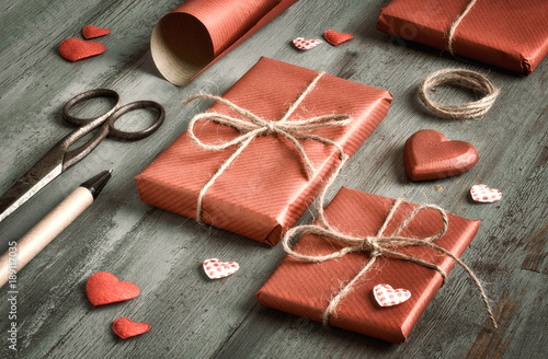 Packed presents, wrapped in red paper with decorative  hearts, cissors and pen for signing photo