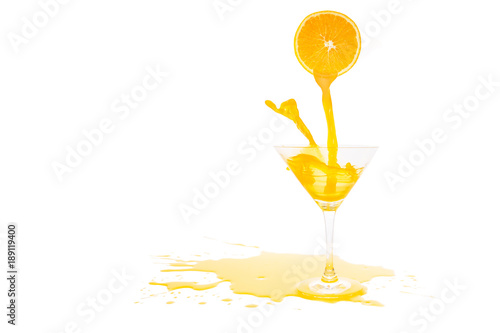 orange juice pouring in glass from half of orange isolated on white background
