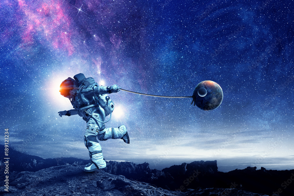 Naklejka premium Fantasy image with spaceman catch planet. Mixed media